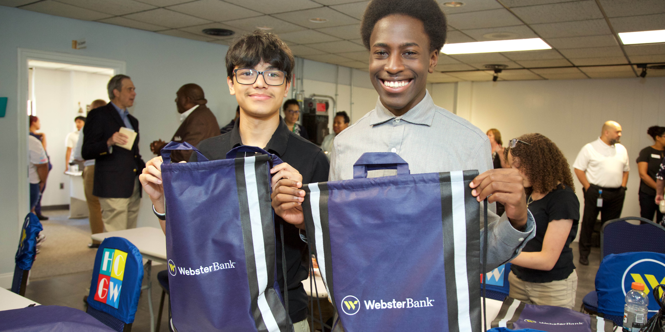 Two students each holding Webster Bank gift bags